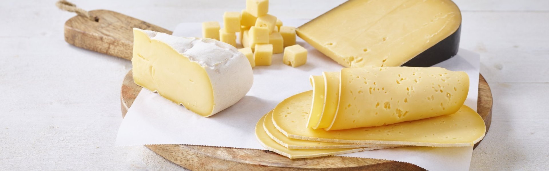 Assortiment kazen van bij ons Houten snijplank gevuld met een assortiment kazen van bij ons. Sneetjes kaas van Passendale, stukje Belgische brie, blok harde Brugge oud kaas en enkele gesneden blokjes Grimbergenkaas.