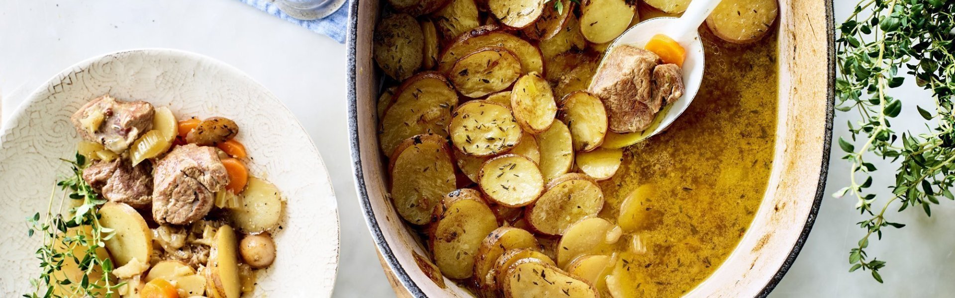 Stoofpotje met lamsvlees staat klaar op tafel om uit geschept te worden. Bovenop de stoofpot ligt een laagje krokante aardappelschijfjes. Deze stoofpot noemt men Lancashire hotpot. 